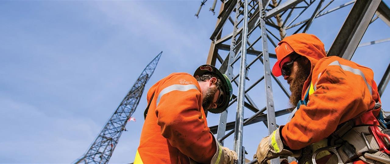 Photo of Hydro One workers on a transmission tower